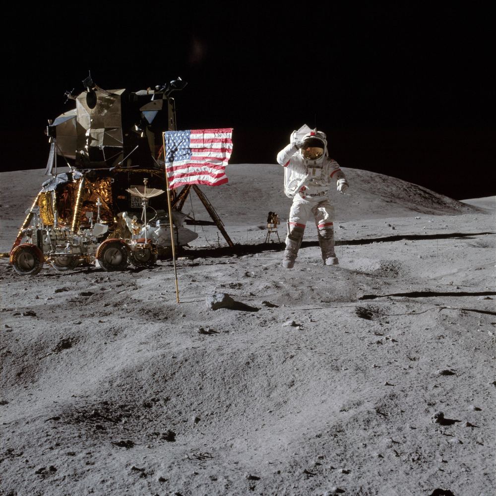 John Young leaping in a salute beside the flag on the Moon