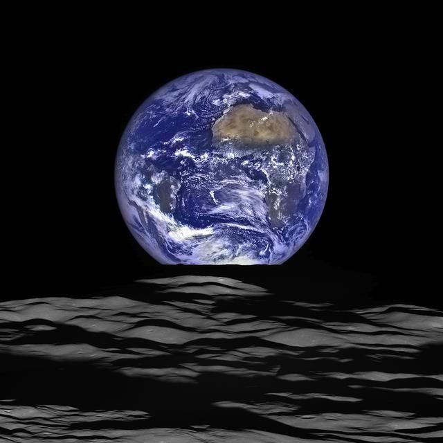 The Earth rising over the barren lunar horizon