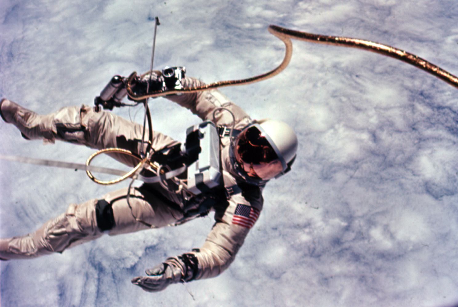 Ed White floating outside Gemini 4 against the blue Earth