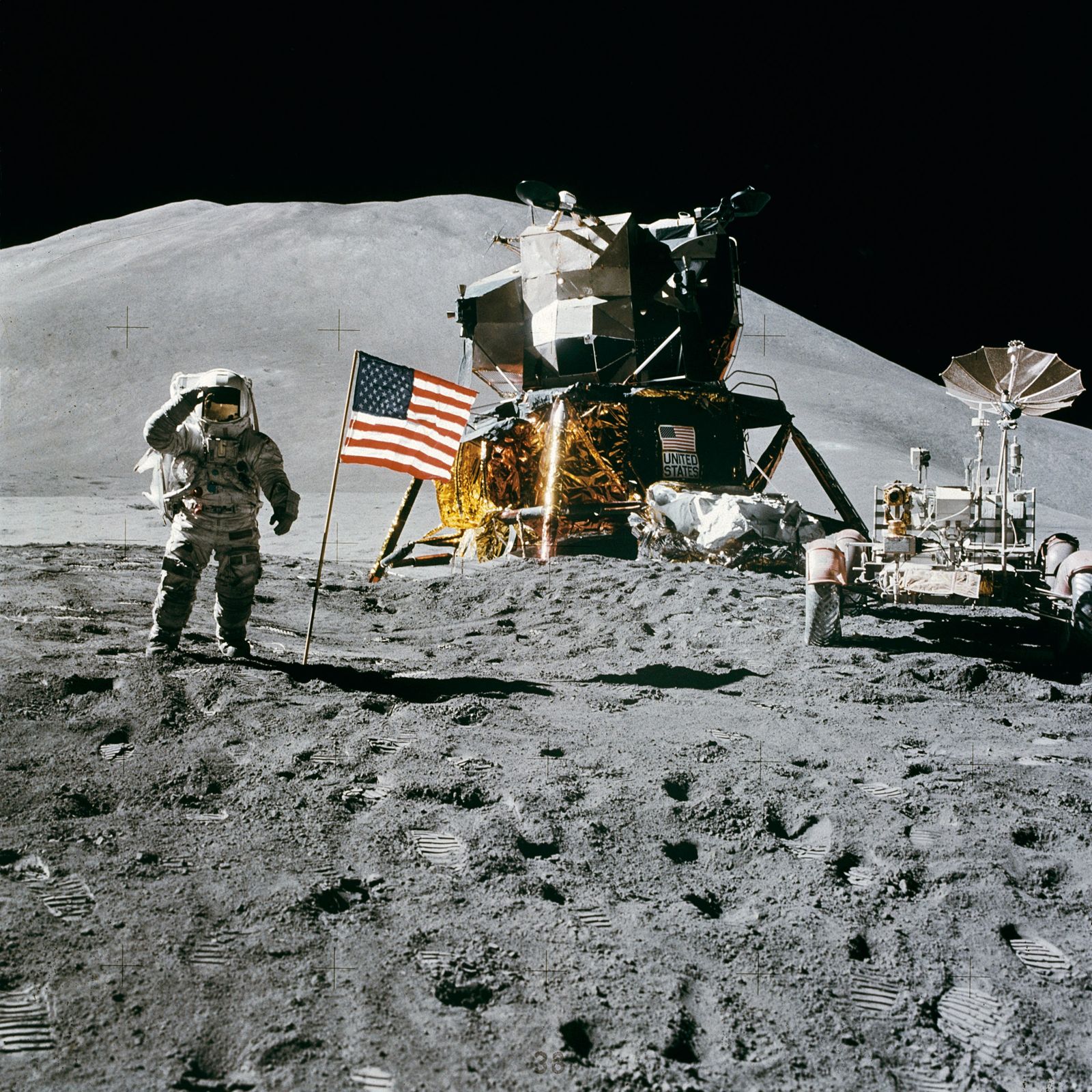 James Irwin saluting the flag, rover and mountains behind him